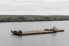 Буксир нажимает баржу вверх по реке стоковая фотография rf Буксир нажимает баржу вверх по реке стоковая фотография rf