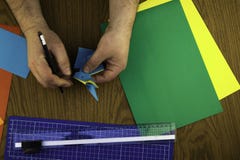 Бумажный зайчик для пасхи, рук делает origami из покрашенной бумаги, экземпляр-затира урока origami стоковое фото rf Бумажный зайчик для пасхи, рук делает origami из покрашенной бумаги, экземпляр-затира урока origami стоковое фото rf