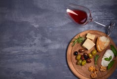 Бутылка и бокал вина с сыром, оливками, хлебом, гайками и розмариновым маслом на темной предпосылке Концепция вина и еды, знамя стоковые изображения rf Бутылка и бокал вина с сыром, оливками, хлебом, гайками и розмариновым маслом на темной предпосылке Концепция вина и еды, знамя стоковые изображения rf