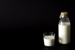 Бутылка и стекло молока Черная предпосылка стоковое изображение rf Бутылка и стекло молока Черная предпосылка стоковое изображение rf