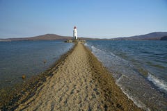 В море заполненном дороге к маяку, в середине линии пляжа моря проходит стоковые изображения В море заполненном дороге к маяку, в середине линии пляжа моря проходит стоковые изображения