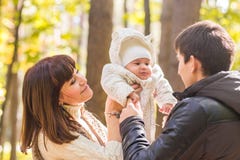 Влюбленность, родительство, семья, сезон и концепция людей - усмехаясь пары с младенцем в осени паркуют стоковое фото rf Влюбленность, родительство, семья, сезон и концепция людей - усмехаясь пары с младенцем в осени паркуют стоковое фото rf