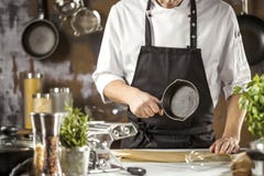 Варить, профессия и концепция людей - мужской кашевар шеф-повара делая еду на кухне ресторана стоковая фотография Варить, профессия и концепция людей - мужской кашевар шеф-повара делая еду на кухне ресторана стоковая фотография