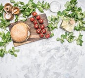 Варящ домодельную куриную котлету бургера, и гарнир салата с томатами вишни, приправами и маслом, на белом rusti стоковые изображения Варящ домодельную куриную котлету бургера, и гарнир салата с томатами вишни, приправами и маслом, на белом rusti стоковые изображения