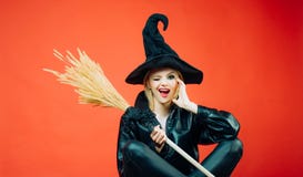 Ведьма держа веник или broomstick женщины oung в черных костюмах хеллоуина ведьмы на партии над красной предпосылкой Счастливый стоковые фотографии rf Ведьма держа веник или broomstick женщины oung в черных костюмах хеллоуина ведьмы на партии над красной предпосылкой Счастливый стоковые фотографии rf