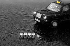 Великобританский традиционный черный автомобиль игрушки такси кабины с наймом слова на шариках Стоковое Изображение Великобританский традиционный черный автомобиль игрушки такси кабины с наймом слова на шариках Стоковое Изображение