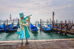 Венецианская замаскированная модель от масленицы 2015 Венеции с гондолами на заднем плане около площади Сан Marco, Venezia, Итали стоковая фотография rf Венецианская замаскированная модель от масленицы 2015 Венеции с гондолами на заднем плане около площади Сан Marco, Venezia, Итали стоковая фотография rf