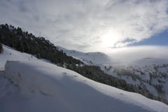 Верхняя часть гор при лес покрытый с снегом, туманом и облаками на солнечный морозный день стоковая фотография rf Верхняя часть гор при лес покрытый с снегом, туманом и облаками на солнечный морозный день стоковая фотография rf