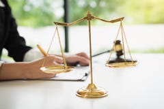 Весы правосудия на белой предпосылке таблицы с женскими юристами работая на юридических фирмах стоковое фото rf Весы правосудия на белой предпосылке таблицы с женскими юристами работая на юридических фирмах стоковое фото rf