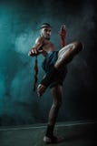 Взгляд низкого угла решительно бойца Muay тайского тренируя тайский бокс стоковая фотография rf Взгляд низкого угла решительно бойца Muay тайского тренируя тайский бокс стоковая фотография rf