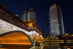 Взгляд ночи красивого моста Anshun над рекой Jinjiang, и центром города Jiuyanqiao в голубом часе стоковые фотографии rf Взгляд ночи красивого моста Anshun над рекой Jinjiang, и центром города Jiuyanqiao в голубом часе стоковые фотографии rf