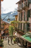 Взгляд переулка в горном склоне, зданий с вьюнком и озера Como в Bellagio стоковые изображения rf Взгляд переулка в горном склоне, зданий с вьюнком и озера Como в Bellagio стоковые изображения rf