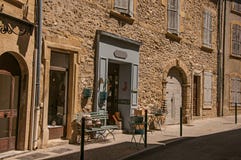 Взгляд типичных каменных домов и магазинов на улице Lourmarin стоковое фото rf Взгляд типичных каменных домов и магазинов на улице Lourmarin стоковое фото rf