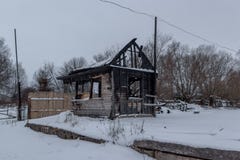 Взгляд вечера на выгоревшем малом деревянном доме в лесе зимы Стоковые Фото Взгляд вечера на выгоревшем малом деревянном доме в лесе зимы Стоковые Фото