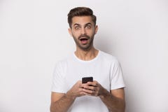 Взгляд Гай на съемке студии изумления смартфона удерживания камеры чувствуя стоковые фото Взгляд Гай на съемке студии изумления смартфона удерживания камеры чувствуя стоковые фото
