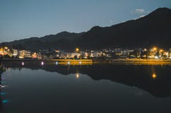 Взгляд ландшафта города ночи с предпосылкой горы и отражение облачного неба на воде расположенной на SAPA, Вьетнаме стоковые изображения rf Взгляд ландшафта города ночи с предпосылкой горы и отражение облачного неба на воде расположенной на SAPA, Вьетнаме стоковые изображения rf