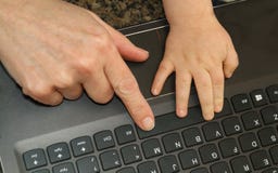Взгляд от верхней части пальца женщины и руки childs на компьтер-книжке k стоковые изображения Взгляд от верхней части пальца женщины и руки childs на компьтер-книжке k стоковые изображения