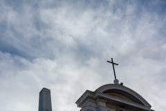 Взгляд от вниз к поднимающему вверх креста на частично облачном небе Backgr стоковая фотография rf Взгляд от вниз к поднимающему вверх креста на частично облачном небе Backgr стоковая фотография rf