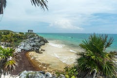 Взгляд пляжа и океана под виском руин бога ветра майяских в Tulum стоковое изображение rf Взгляд пляжа и океана под виском руин бога ветра майяских в Tulum стоковое изображение rf