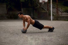 Взгляд со стороны atlethic, тонизированного молодого человека делать нажимает поднимает с разминкой баскетбола на открытом воздух стоковое фото Взгляд со стороны atlethic, тонизированного молодого человека делать нажимает поднимает с разминкой баскетбола на открытом воздух стоковое фото