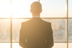 Вид сзади мужского работника офиса смотря окно стоковое фото rf Вид сзади мужского работника офиса смотря окно стоковое фото rf