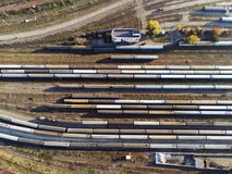 Вид с воздуха двора железной дороги с поездами пассажира и груза на рельсе стоковое фото rf Вид с воздуха двора железной дороги с поездами пассажира и груза на рельсе стоковое фото rf