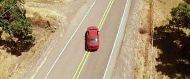 Вид с воздуха, красные повороты автомобиля вне дороги стоковое изображение Вид с воздуха, красные повороты автомобиля вне дороги стоковое изображение