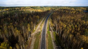 Вид с воздуха проселочной дороги через лес в осени фотография трутня стоковое фото rf Вид с воздуха проселочной дороги через лес в осени фотография трутня стоковое фото rf