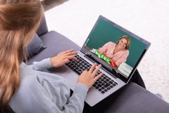 Видео конференц-связь девушки с учителем на ноутбуке стоковое изображение Видео конференц-связь девушки с учителем на ноутбуке стоковое изображение