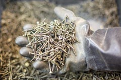 Винты в руке, руке в резиновой перчатке, концепции конструкции стоковые фото Винты в руке, руке в резиновой перчатке, концепции конструкции стоковые фото