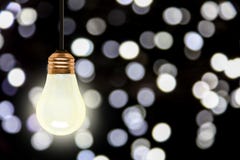 Вися электрическая лампочка с предпосылкой светов Bokeh рождества стоковое фото rf Вися электрическая лампочка с предпосылкой светов Bokeh рождества стоковое фото rf