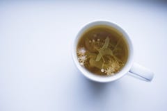 Вкусная травяная чашка чаю на белой таблице стоковая фотография rf Вкусная травяная чашка чаю на белой таблице стоковая фотография rf