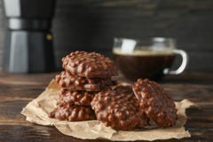 Вкусные печенья шоколада с чашкой кофе на деревянном столе стоковая фотография Вкусные печенья шоколада с чашкой кофе на деревянном столе стоковая фотография