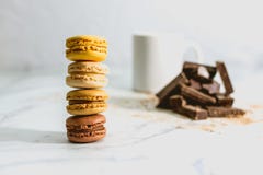 Вкусные сладкие macarons с чашкой кофе на предпосылке стоковая фотография rf Вкусные сладкие macarons с чашкой кофе на предпосылке стоковая фотография rf