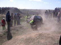 Внедорожные ассистенты конкуренции помочь автомобилю преодолевать препону рядом с толпой зрителей стоковая фотография rf Внедорожные ассистенты конкуренции помочь автомобилю преодолевать препону рядом с толпой зрителей стоковая фотография rf