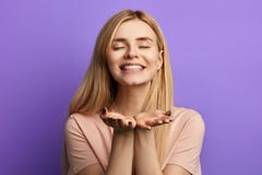 Внушительная шаловливая жизнерадостная молодая женщина отправляя поцелуй над голубой предпосылкой стоковая фотография Внушительная шаловливая жизнерадостная молодая женщина отправляя поцелуй над голубой предпосылкой стоковая фотография