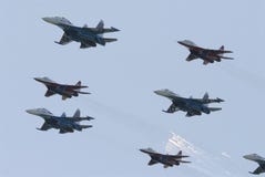 Военный самолет MIG 29 и SU 27 выполняют совместный полет на авиасалоне в Pushkin России 2007 стоковое фото Военный самолет MIG 29 и SU 27 выполняют совместный полет на авиасалоне в Pushkin России 2007 стоковое фото