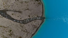 Воздушная съемка голубого ледникового озера Blavatnet и реки опорожняет в ее, Lyngen Альпы стоковое изображение rf Воздушная съемка голубого ледникового озера Blavatnet и реки опорожняет в ее, Lyngen Альпы стоковое изображение rf