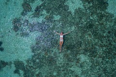Воздушный взгляд сверху женщины плавая в кристально ясное море стоковые фото Воздушный взгляд сверху женщины плавая в кристально ясное море стоковые фото