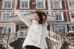 Воодушевленная женщина скача в солнечный зимний день, наслаждаясь праздниками рождества На открытом воздухе фото смешной женской стоковое фото rf Воодушевленная женщина скача в солнечный зимний день, наслаждаясь праздниками рождества На открытом воздухе фото смешной женской стоковое фото rf
