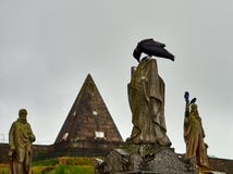 Ворона ища еда вверху статуя, кладбище Стерлинга, Шотландия стоковые изображения Ворона ища еда вверху статуя, кладбище Стерлинга, Шотландия стоковые изображения