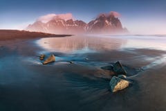 Восход солнца на горная цепь Vestrahorn Stokksnes с горой Brunnhorn также видимой в расстоянии Исландия Seascape стоковая фотография Восход солнца на горная цепь Vestrahorn Stokksnes с горой Brunnhorn также видимой в расстоянии Исландия Seascape стоковая фотография