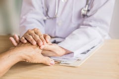Врачуйте держать руку и утешать старого пациента в больнице стоковое фото Врачуйте держать руку и утешать старого пациента в больнице стоковое фото