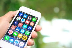 Вручите держать iPhone с социальными применениями средств массовой информации на экране стоковое изображение Вручите держать iPhone с социальными применениями средств массовой информации на экране стоковое изображение
