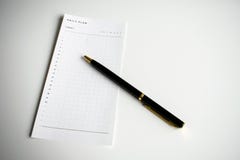 Всечасный ежедневный план для того чтобы сделать список с черной ручкой стоковое изображение Всечасный ежедневный план для того чтобы сделать список с черной ручкой стоковое изображение