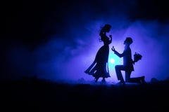 Вы поженитесь я? Силуэт молодого человека оставаясь на колене и делая предложение для его симпатичной девушки на пляже против тем стоковое фото Вы поженитесь я? Силуэт молодого человека оставаясь на колене и делая предложение для его симпатичной девушки на пляже против тем стоковое фото