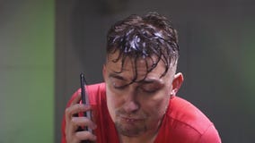Вымотанный потеть красный t-shirted человек делать cardio и говорить по телефону видеоматериал Вымотанный потеть красный t-shirted человек делать cardio и говорить по телефону видеоматериал
