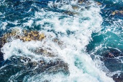 Выплеск волны моря океана на скалистом береге, серия пены и синяя вода стоковая фотография Выплеск волны моря океана на скалистом береге, серия пены и синяя вода стоковая фотография