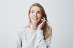 Выразительная счастливая молодая кавказская женщина носит волосы покрашенные блондинкой свободно, слушает к музыке в наушниках, н стоковое фото Выразительная счастливая молодая кавказская женщина носит волосы покрашенные блондинкой свободно, слушает к музыке в наушниках, н стоковое фото