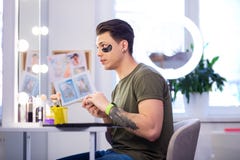 Выразительный любопытный человек проверяя его взгляд в отражении зеркала стоковое изображение Выразительный любопытный человек проверяя его взгляд в отражении зеркала стоковое изображение
